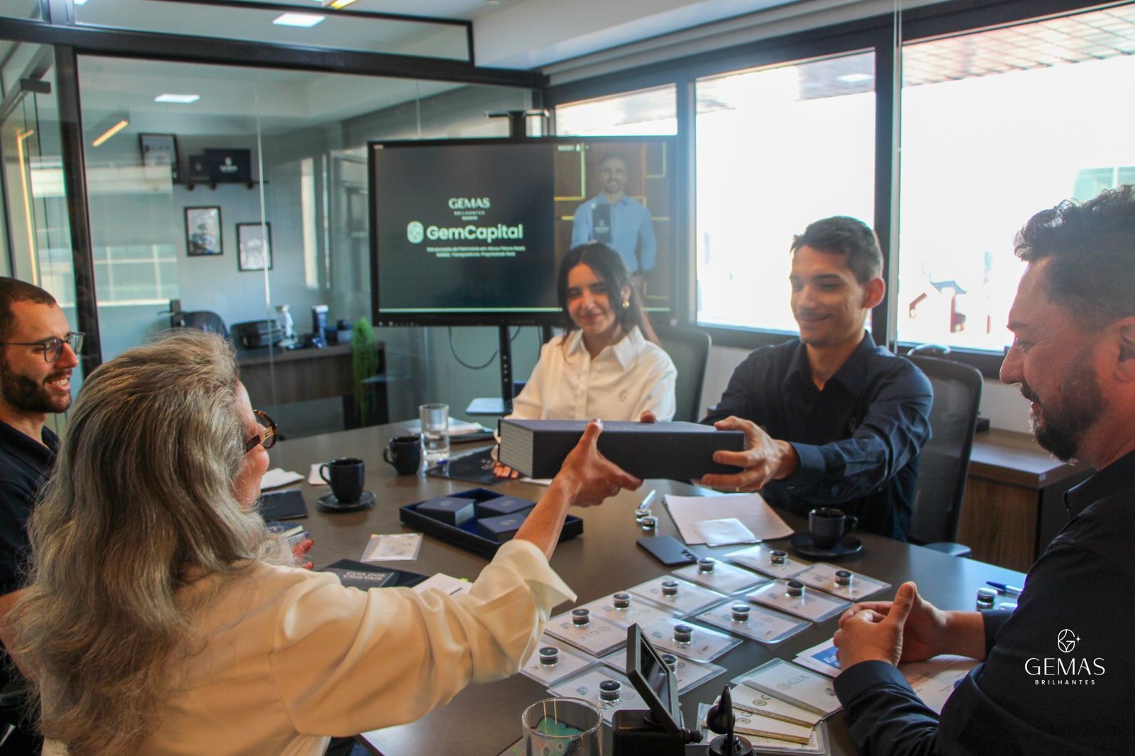 Time do GemCapital entregando um diamante certificado em reunião com clientes